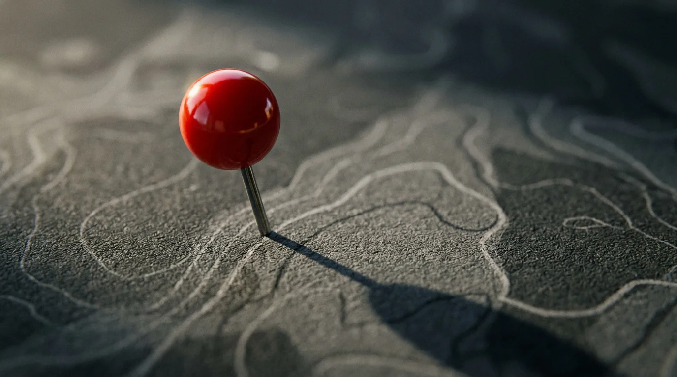 A red location pin casting a long shadow on a minimalist dark map.